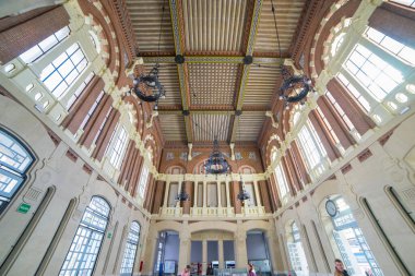 İspanya 'nın Aranjuez kentindeki Renfe tren istasyonunda ziyaretçiler, 25 Mart 2018' de istasyonun tarihsel önemini vurgulayarak karmaşık tasarıma ve yüksek ahşap tavana hayran kaldılar..