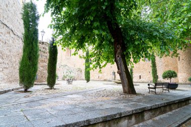 Ziyaretçiler, taş duvarlar ve canlı yeşilliklerle çevrili Brihuega 'nın huzurlu avlusunda dinleniyorlar. Atmosfer, kasabanın zengin mirasını tefekkür etmeye ve keşfetmeye davet ediyor..