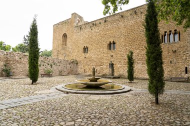 Brihuega 'daki sakin bir avluda yemyeşil ve antik duvarlarla çevrili taştan bir çeşme sergileniyor. İspanya 'nın tarihi manzarasında barışçıl bir geri çekilme..