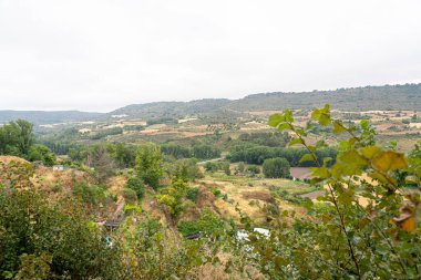 İspanya, Brihuega 'daki kayan tepelerin ve bereketli manzaraların manzaraları Castilla-La Mancha' daki doğanın güzelliğini gözler önüne seriyor. Yeşil bitki örtüsü, bulutlu gökyüzünün altındaki altın ekinlerle çelişiyor..