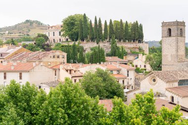 Brihuega 'nın göz kamaştırıcı manzarası, geleneksel çatıların ve yemyeşil çimlerin sergilendiği antik binalar ve taş bir kule.