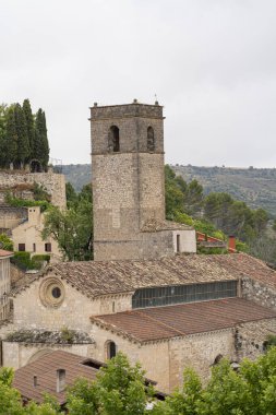 Brihuega 'nın bereketli manzarasının ortasındaki tarihi binalar. Yüksek yapı, yeşil ve yuvarlanan tepelerle çevrili klasik İspanyol mimarisini sergiliyor ve sakin bir atmosfer yaratıyor..