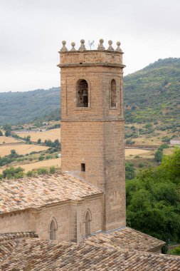 Çan kulesi, Brihuega, Guadalajara 'da, sakin doğal ışıkta sakin bir manzaranın ortasında taş mimarisini sergiliyor..