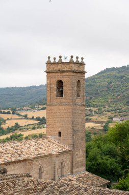 Tarihi bir kilisenin çarpıcı çan kulesi, İspanya 'nın tipik Castilla-La Mancha kentinin verimli tepeleri ve tarlalarıyla çevrili büyüleyici Brihuega kasabasının üzerinde yükseliyor..