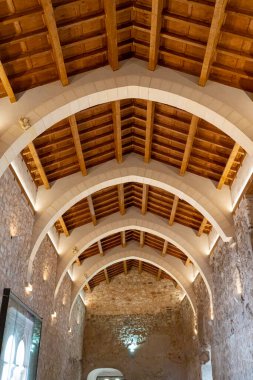 Ziyaretçiler, Brihuega, Guadalajara 'daki tarihi bir binanın içindeki kemerli ahşap tavanları içeren zarif mimariye hayranlık duyuyorlar..