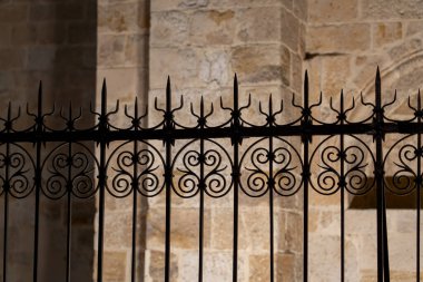 Zamora, Castilla y Leon, İspanya 'da süslü demir bir çit taş bir duvara karşı duruyor..