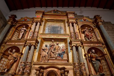 Colegiata de Santa Maria la Mayor de Toro 'da, sunağı süsleyen ahşap oymalar ve canlı renkler, zengin bir kültür mirasından gelen dini figürler ve sanatsal yetenekleri vurguluyor..