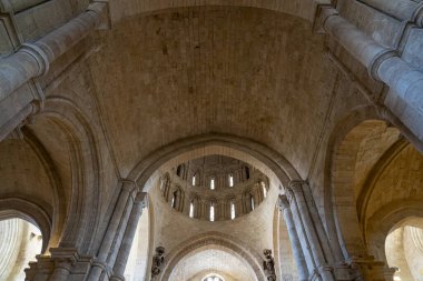 Ziyaretçiler, Colegiata de Santa Maria la Mayor de Toro 'nun etkileyici kemerlerine ve taş işçiliğine hayret ediyorlar. Bina aydınlık gökyüzünün altında çarpıcı bir ortaçağ mimarisi sergiliyor..