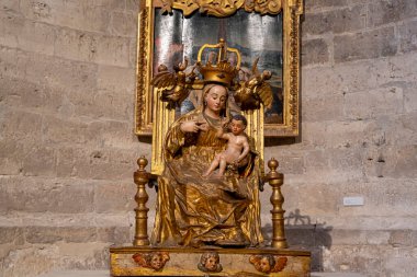 Tarihi Colegiata de Santa Maria la Mayor 'da Meryem Ana' nın altın heykeli İsa 'nın çocuğunu tutarken ziyaretçileri cezbeder. Güneş ışığı karmaşık detayları aydınlatır, güzelliğini arttırır..