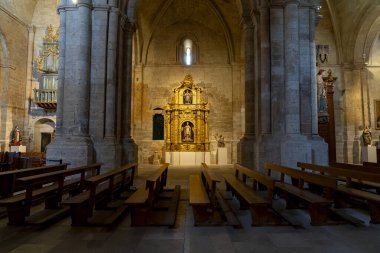 Colegiata de Santa Maria la Mayor de Toro 'nun içinde, güzel tasarlanmış sunak süslü detaylarla parlarken, ahşap banklar İspanya' nın Zamora kentindeki ziyaretçilere oturma olanağı sağlıyor..
