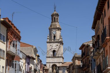 Toro 'daki saat kulesi, zengin tarihi ve mimari güzelliğini gözler önüne sererek şehir merkezinde yer alıyor. Dükkanlar ve binalar parlak mavi bir gökyüzünün altında caddeler boyunca dizilir..
