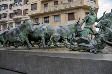 Pamplona, Navarra 'da düzenlenen geleneksel San Fermin festivalinde koşan boğaları ve katılımcıları gösteren bronz bir heykel. Bu sanat eseri olayın heyecanını ve enerjisini gözler önüne seriyor..