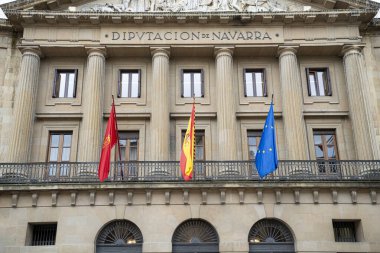 Pamplona, Navarra 'da, tarihi bir hükümet binası, önde İspanya ve AB' yi temsil eden önemli sütunları ve üç bayrağıyla mimari ihtişamını sergiliyor..