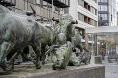 San Fermin heykeli, bir koşucunun geleneksel İspanyol kültürünü sergileyen bir boğayla karşı karşıya geldiği dramatik bir anı tasvir ediyor. Bu sanat eseri canlı Pamplona şehrinde yer almaktadır..