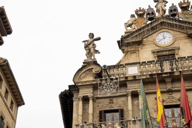 Pamplona 'nın tarihi mimarisinin çarpıcı bir görüntüsünde, bulutlu bir günde bu İspanyol şehrinin kültürel mirasını yansıtan ayrıntılı heykeller ve canlı bayraklar yer alıyor..