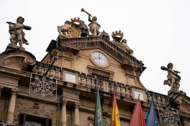 Pamplona 'daki bu yapıda yerel mirası temsil eden belediye binasının tepesindeki özenle hazırlanmış heykeller yer alıyor. Etkileyici cephe, mimari güzelliğini vurgulayan bayraklar ve bir saati içeriyor..