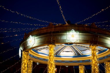 Plaza del Castillo, çardağı süsleyen parıldayan ışıklarla aydınlatma gösterisi sergiliyor. Ziyaretçiler gecenin hareketli atmosferinin keyfini çıkararak yerel gelenekleri kutluyorlar..