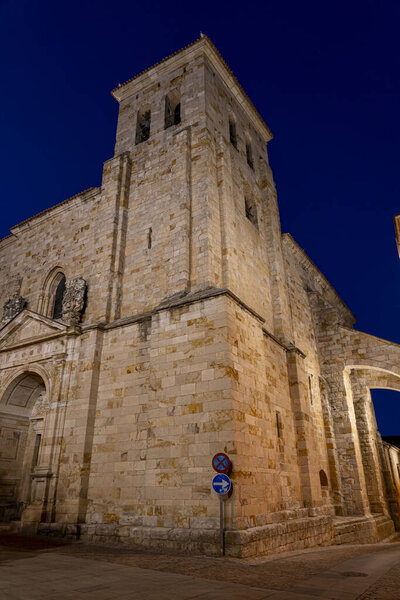 A stunning view of historic architecture in Zamora, Castilla y Leon showcases its stone buildings and tower at dusk. The charming streets add to the evening's allure.