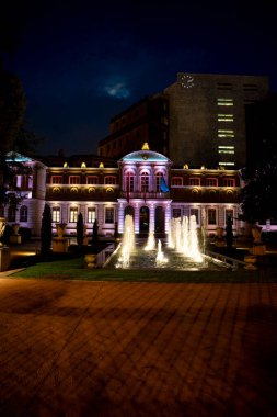 Gece Pamplona, Navarra 'da güzel bir tarihi bina renkli ışıklarla aydınlatılır. Öndeki fıskiyeler büyüleyici bir görüntü yaratarak zarif mimariyi ve atmosferi güçlendirir..