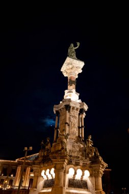 Monumento a los Fueros, Pamplona, Navarra 'da görkemli bir şekilde duruyor. Karmaşık heykeller sergiliyor ve gece gökyüzüne karşı etkileyici ışıklandırma yapıyor. Yerel tarih ve kültürü kutluyor..