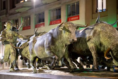 Pamplona 'daki bronz heykel geleneksel San Fermin festivalini sergiliyor. Koşan boğaları ve enerjik figürleri net bir şekilde tasvir ediyor, olayın heyecanını simgeliyor..