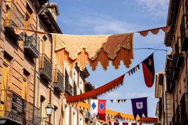 Canlı bir ortaçağ festivali sırasında Alcala de Henares sokaklarını parlak renkli pankartlar ve dekorasyonlar doldurarak, ziyaretçiler ve yerliler için tarih ve kültürü canlandırdı..