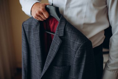 Ceketini tutarak ve bunu giy hazır bakarak iş adamı. Bazı olay ya da yeni iş günü için hazırlanıyor. Yeni fırsatlar, dating, düğün günü, alışveriş veya Çamaşırhane Hizmeti kavramı. Yandan odaklanmak