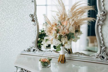 Gelin elinde bir düğün buketi tutuyor..