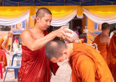 Ban Chang, Tayland - 16 Nisan 2023: Songkran, Budist Yeni Yılı kutlamak için birbirinin üzerine çiçek yapraklarıyla su döken keşişler, Ban Chang, Rayong Eyaleti Wat Chak Mak 'ta, Tayland.