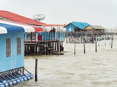 Yağmurlu bir günde Tayland 'ın güneyindeki Songkhla Gölü' nde balıkçıların evlerine sahip bir balık çiftliği.. 