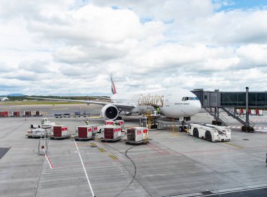 Gardermoen, Norveç - 22 Ağustos 2022: Emirates Boeing 777-300ER, Oslo Havaalanı, Gardermoen 'in kapısında, kalkıştan önce kargo ve bagaj konteynerleriyle yükleniyor..