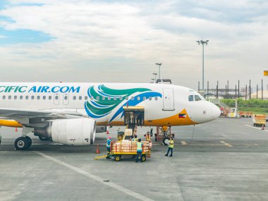 Manila, Filipinler - 8 Temmuz 2017: Kargo Pasay City, Manila 'daki Ninoy Aquino Uluslararası Havaalanı Terminali' nde Cebu Pacific Airbus A320 'ye yükleniyor.