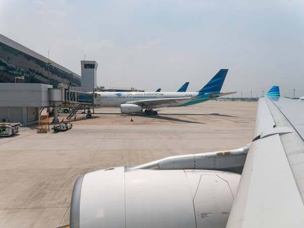 Jakarta, Indonesia - October 21, 2017: Two Airbus A330 in the livery of Garuda Indonesia, one in the foreground and one in the background, at Soekarno-Hatta International Airport waiting for departure.