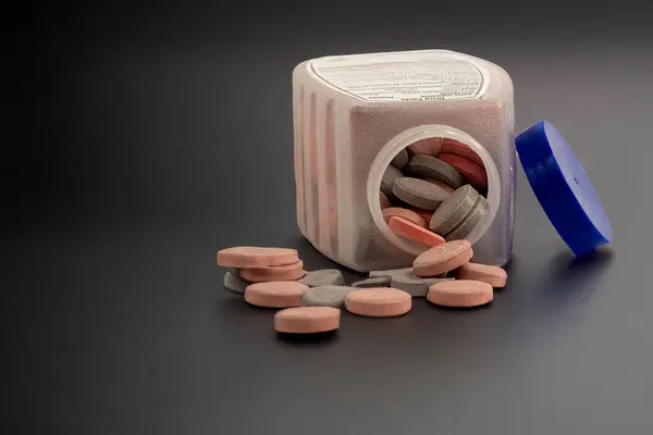 Açılmış bir şişe Antacid döküldü. Yüzeyde bazı haplar var..