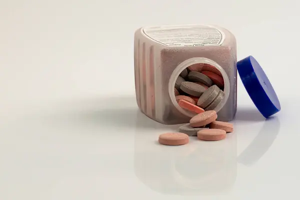 Açılmış bir şişe Antacid döküldü. Yüzeyde bazı haplar var..