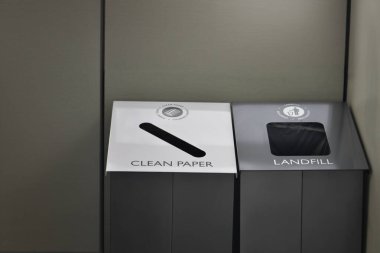 Bir ofis ortamında temiz kağıt ya da çöplük geri dönüşümü için bir geri dönüşüm kutusu seti.