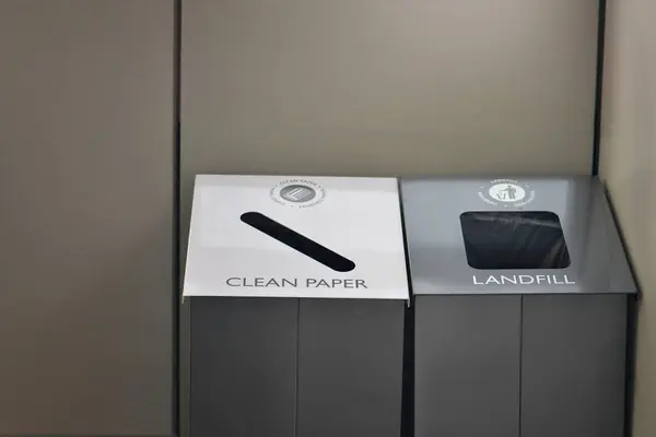 Bir ofis ortamında temiz kağıt ya da çöplük geri dönüşümü için bir geri dönüşüm kutusu seti.