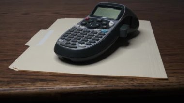 Bir etiket makinesi üzerinde Bütçe 2025 yazılı bir etiket basıyor..