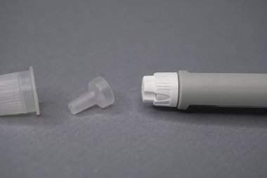 Enjeksiyon kaleminin ucu iğneden sallanan iğnenin küçük bir damlasını gösteriyor..