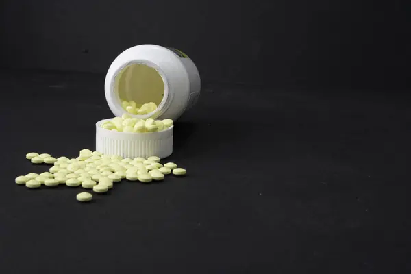 Bir kutu Aspirin devrilir ve bebek aspirini dökülür..