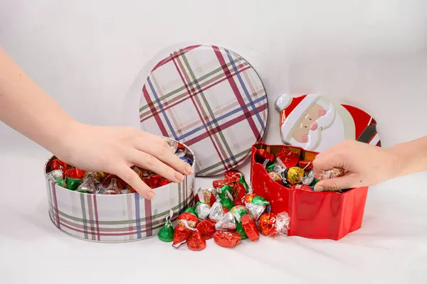 İki genç kızın elleri Noel şekeri kutularına uzanıyor..