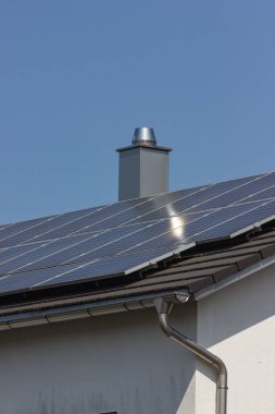 Güney Almanya 'da güneşli bahar gününde inşaat iskelesi olan çatıdaki güneş paneli.