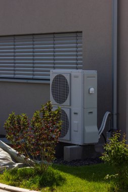Bahar zamanı güneşli bir günde, güney Almanya 'nın modern ev cepheleriyle yeni bir binada ısı pompası.