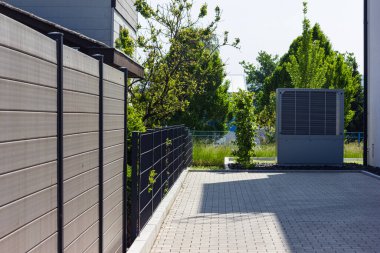 Bahar zamanı güneşli bir günde, güney Almanya 'nın modern ev cepheleriyle yeni bir binada ısı pompası.