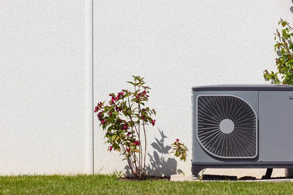 Bahar zamanı güneşli bir günde, güney Almanya 'nın modern ev cepheleriyle yeni bir binada ısı pompası.
