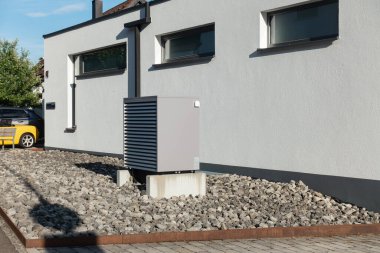 Yazın güneşli bir günde, güney Almanya 'nın modern ev cepheleriyle yeni bir binada sıcak hava pompası.