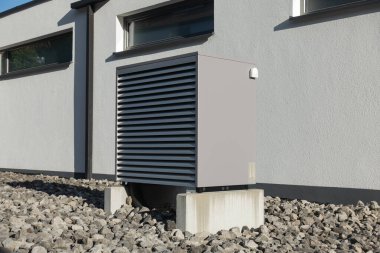 Yazın güneşli bir günde, güney Almanya 'nın modern ev cepheleriyle yeni bir binada sıcak hava pompası.