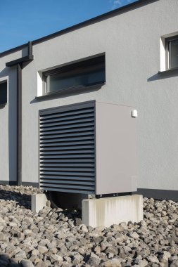 Yazın güneşli bir günde, güney Almanya 'nın modern ev cepheleriyle yeni bir binada sıcak hava pompası.