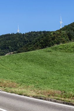 Yeşil orman ve tarımsal alan yakınlarındaki doğal çevrede rüzgar türbini
