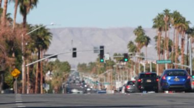 Odaklanamayan palmiye ağaçları, güneşli Palm Springs şehir trafiği, Los Angeles, California, ABD yakınlarındaki tatil beldesi. Dağlık vadide iklim çölleri vahası, yaz gezisi atmosferi. Araba sürüyor..